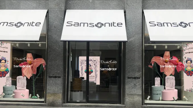 Vetrina del flagship store Samsonite con allestimento dedicato alla collezione Frida Kahlo x Samsonite durante la Design Week, con elementi floreali, valigie illustrate e ritratti artistici