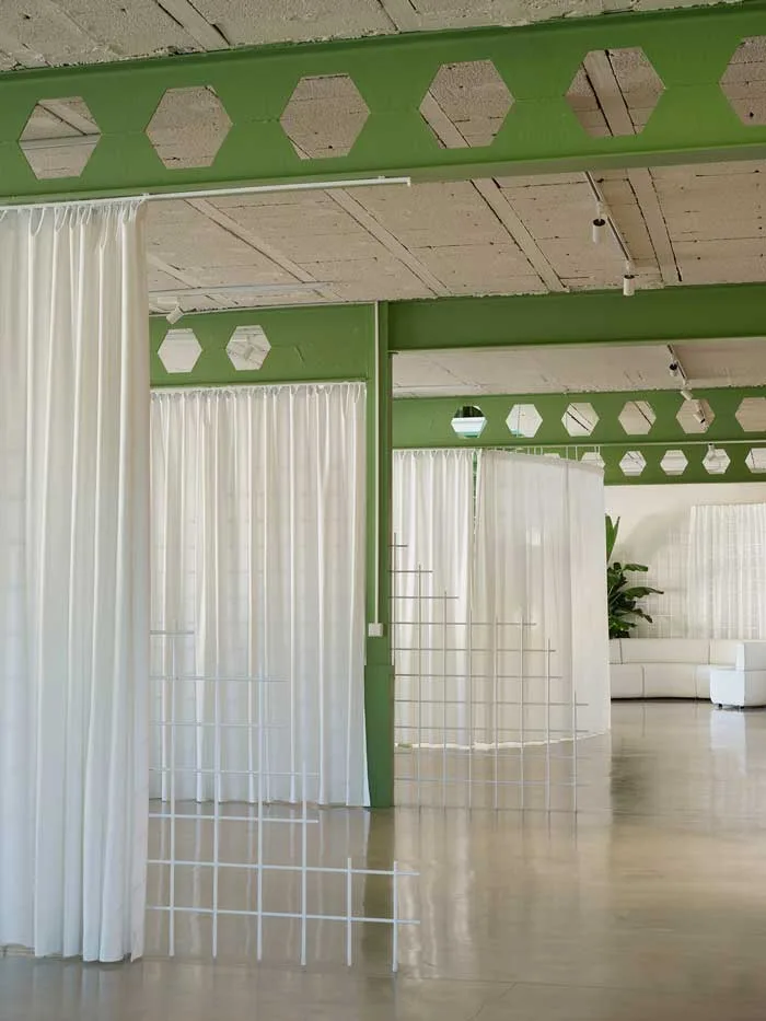headquarter-di-federico-giner-firmato-clap-studio Interni del nuovo headquarter di Federico Giner con tende bianche divisorie, struttura in acciaio verde e griglie geometriche progettati da Clap Studio