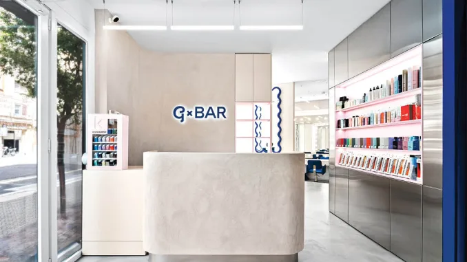 Reception minimalista del salone di bellezza GxBar a Barcellona, progettato da HVYLYA Design con interior design contemporaneo, materiali materici e pareti in intonaco sabbioso