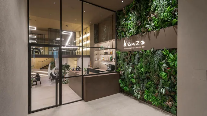 Esterno del ristorante Konza con ingresso illuminato e logo