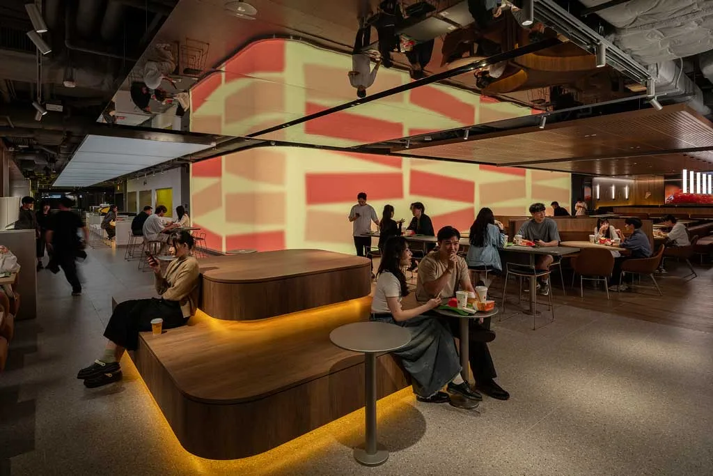 Mood Engine McDonald’s Hong Kong con sedute in legno illuminate e proiezione dinamica