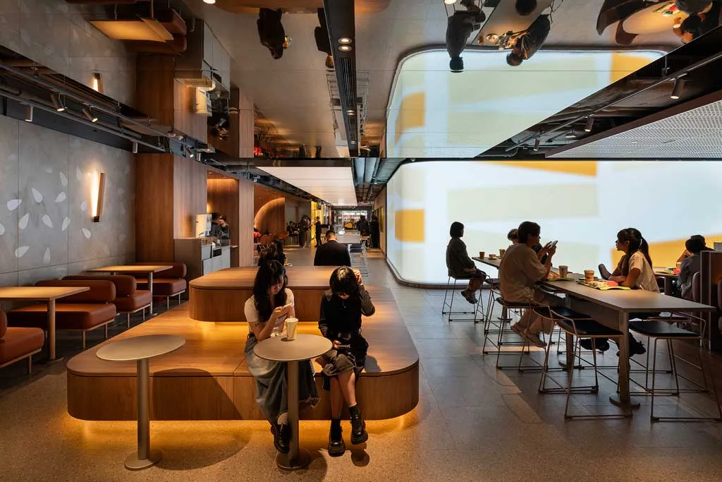 Interni McDonald’s Hong Kong con Mood Engine curvo e sedute minimal in legno