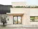 Ingresso del nuovo headquarter di Federico Giner progettato da Clap Studio, con facciata in mattoni chiari, struttura geometrica in metallo e vegetazione sulla terrazza