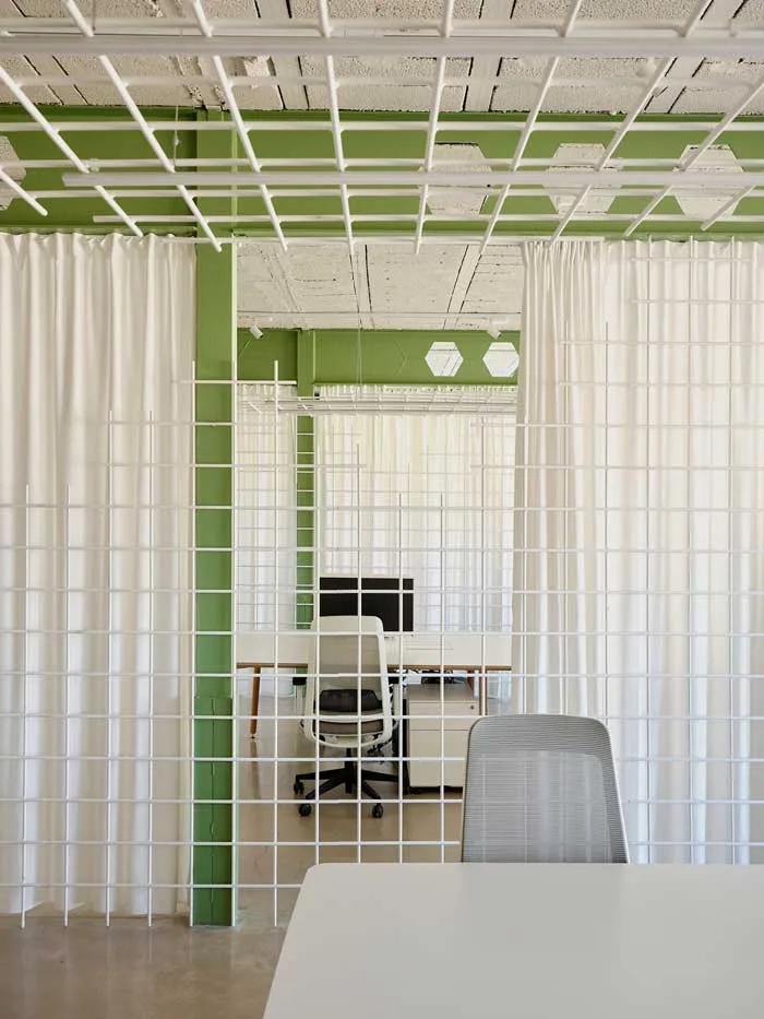 nuovo-headquarter-federico-giner-by-clap-studio_700x933 Postazioni operative all’interno del nuovo headquarter di Federico Giner, suddivise da griglie metalliche bianche e tende, con struttura architettonica verde progettata da Clap Studio