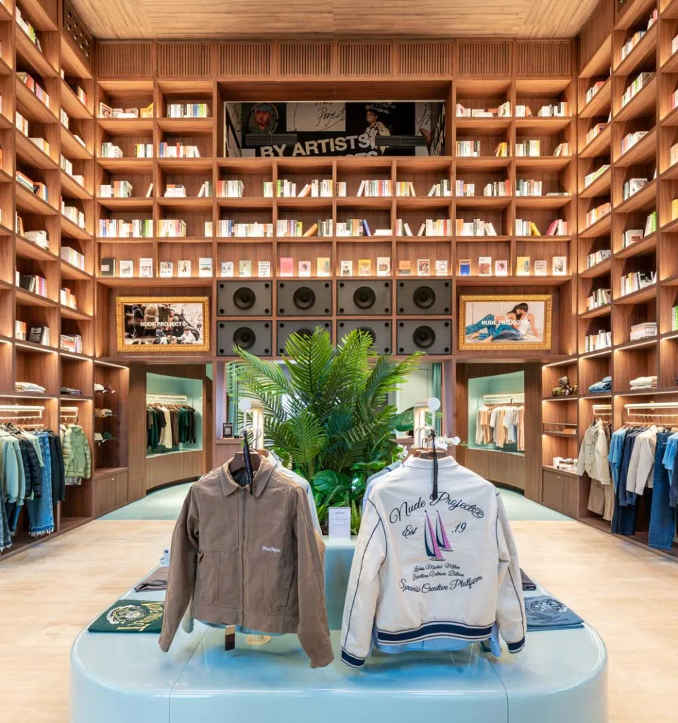 Interior of the Nude Project flagship store with six-meter-high wooden library, audio console and displayed garments