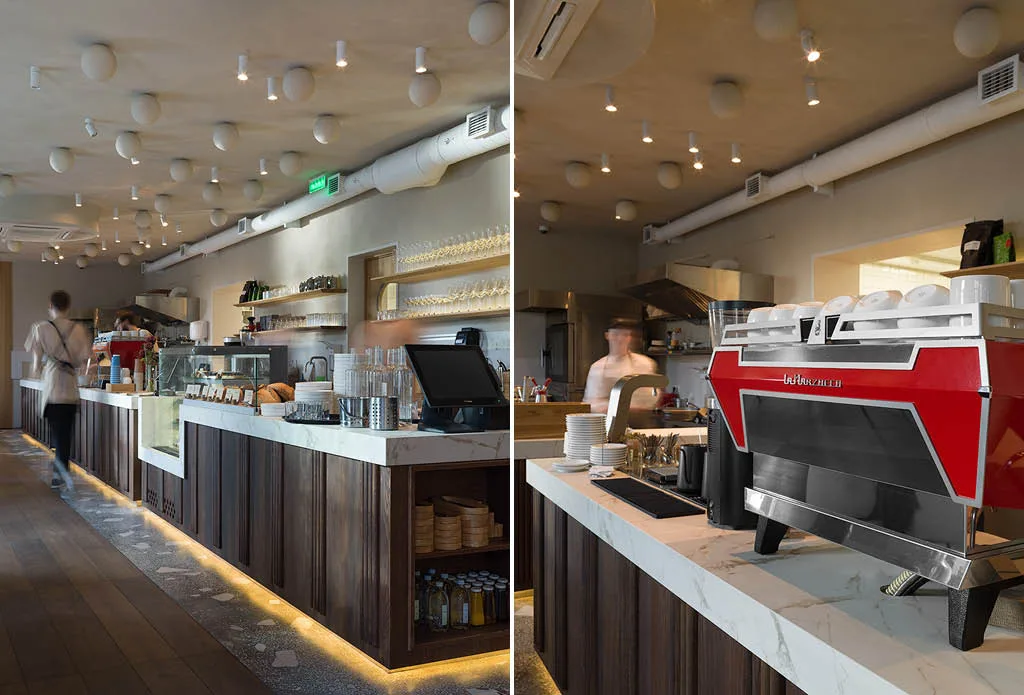 Counter of Ember Café in Saratov with red coffee machine, dark wood finishes and marble-effect porcelain stoneware top