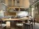 Ampio tavolo conviviale con lampada a sospensione e albero da interno – layout multifunzionale per una caffetteria dall’atmosfera rilassata.
