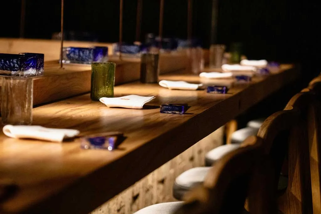 The table of the counter is made of wood, while the structure is crafted from Neapolitan tuff, a covering material that evokes the traditional Japanese Oya-Ishi stone