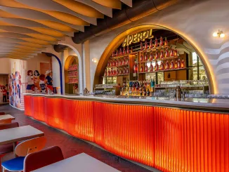 Il bancone iconico della Terrazza Aperol Milano con design arancione e bottiglie di Aperol in esposizione