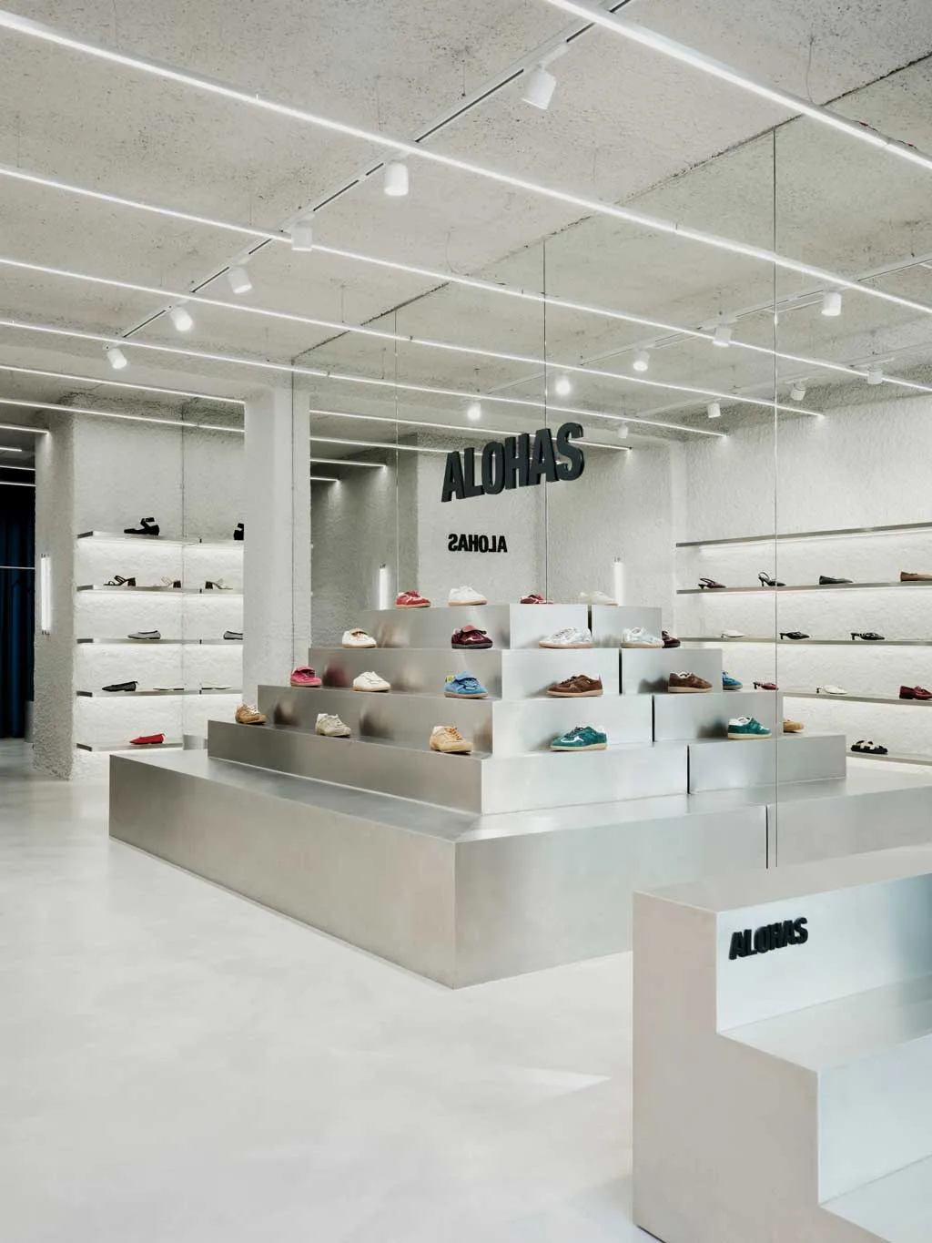 Espositore piramidale in metallo specchiato nel flagship store ALOHAS a Madrid, ideato da Clap Studio come simbolo di energia e trasformazione