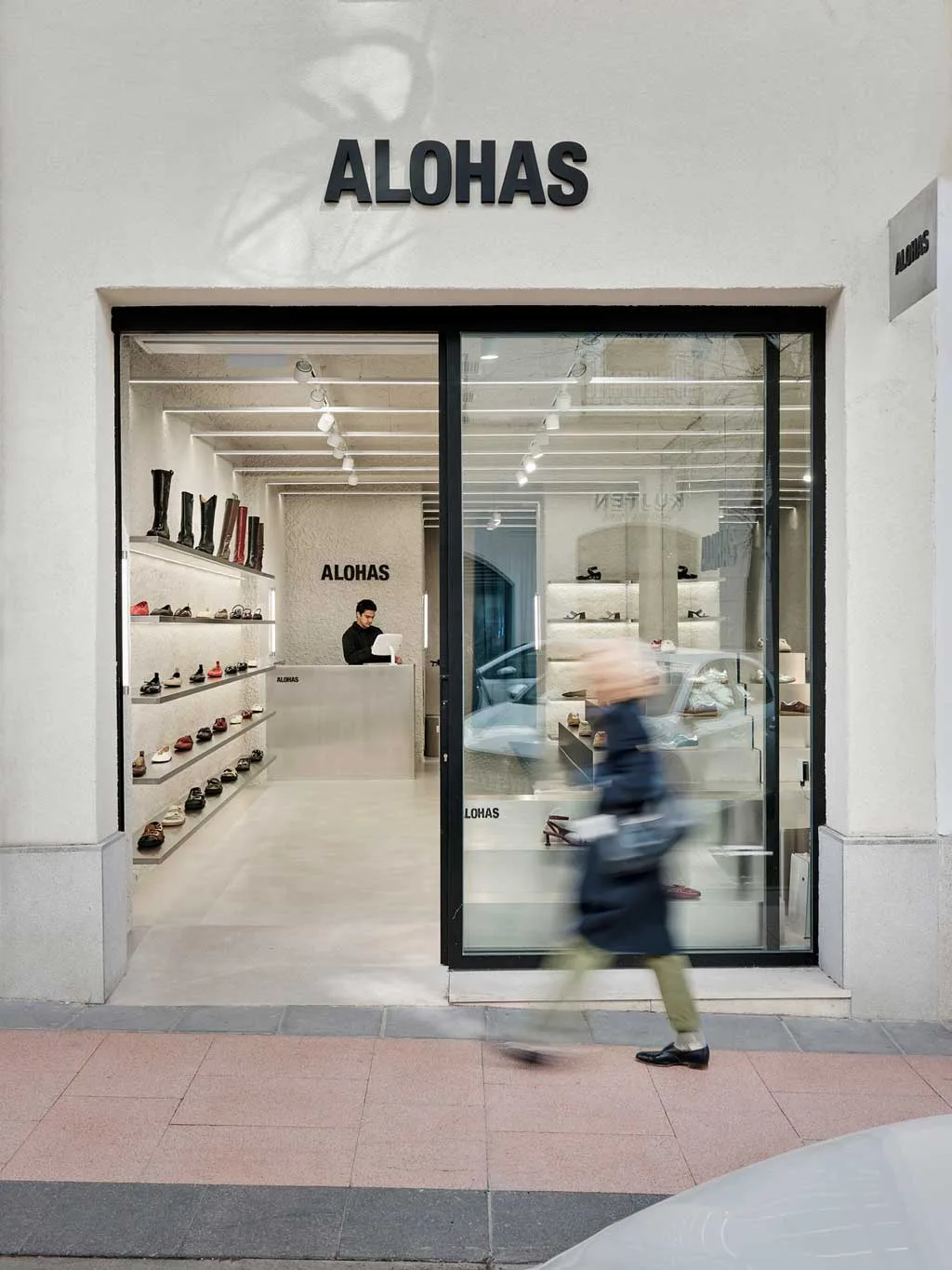 Vista esterna del flagship store ALOHAS a Madrid con ampie vetrine che rivelano gli interni materici progettati da Clap Studio