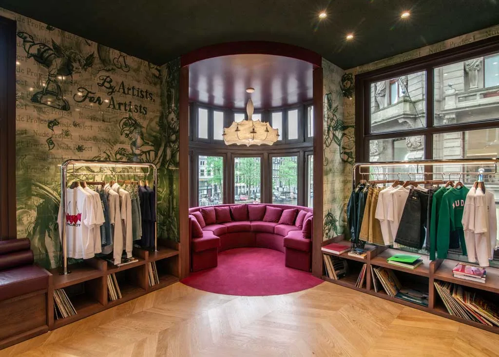 Spazio “Lolita” del flagship store Nude Project con divano curvo e dettagli in velluto rosso