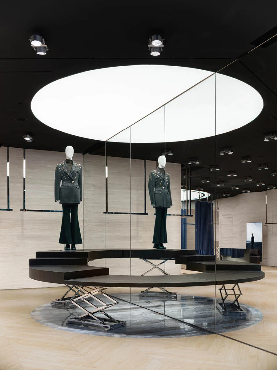 Area espositiva circolare con specchi e pedane mobili nella boutique MITHRIDATE a Guangzhou