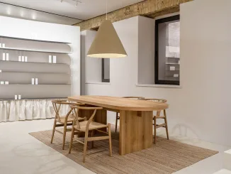 Zona consulenza del PLEKA Showroom a Kyiv con tavolo in legno e sedute in stile nordico