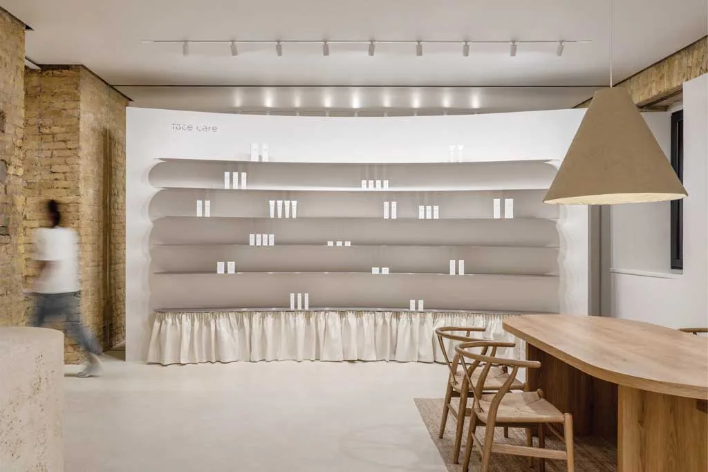 Minimal display wall in the PLEKA Showroom in Kyiv with wavy shelving and soft-touch materials