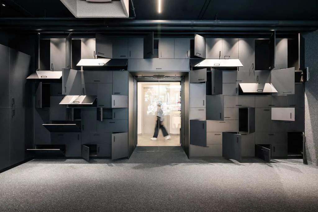 Parete attrezzata con armadietti modulari e dinamici nella sede ADDITIVE a Bolzano, esempio di progettazione flessibile firmata NOA