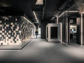 Interni della sede ADDITIVE a Bolzano: progettazione di spazi di lavoro flessibili con box modulari e pareti rivestite in piastrelle geometriche