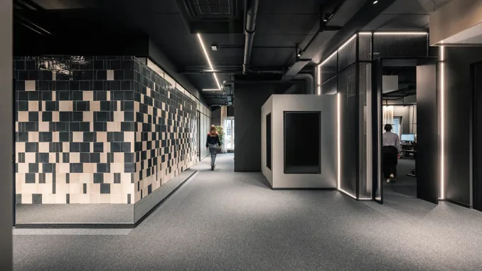 Interni della sede ADDITIVE a Bolzano: progettazione di spazi di lavoro flessibili con box modulari e pareti rivestite in piastrelle geometriche