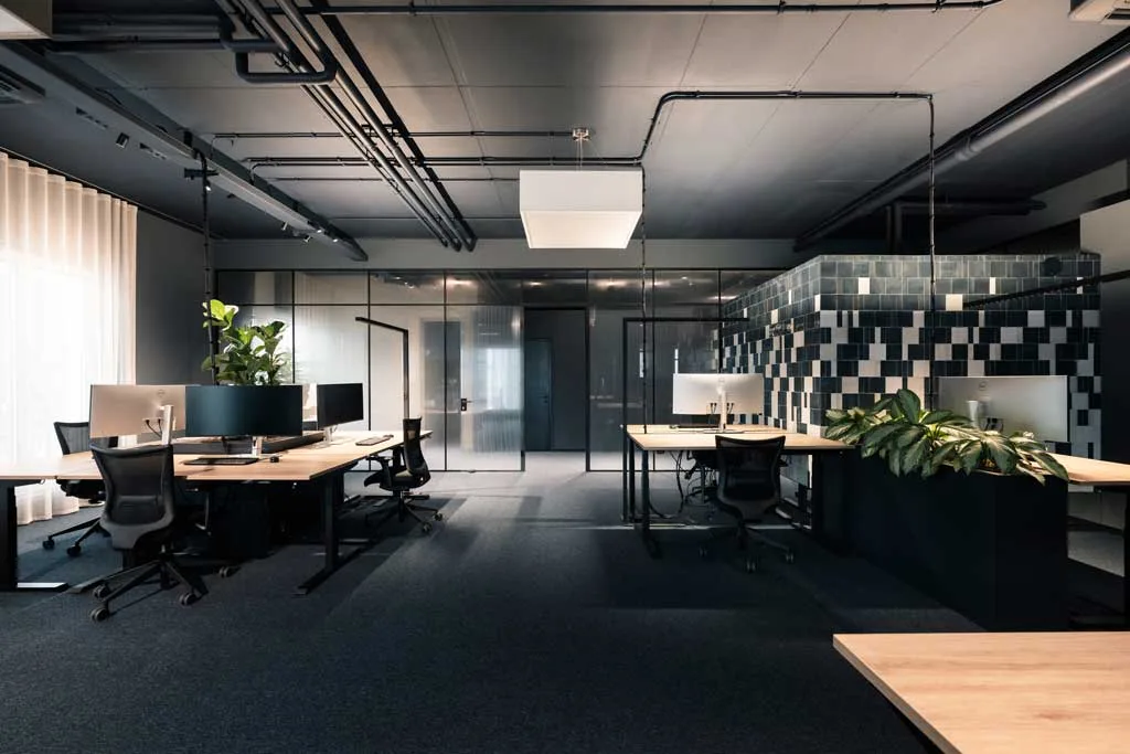 Uffici open space della sede ADDITIVE a Bolzano con postazioni flessibili, pareti modulari piastrellate e interior design firmato NOA