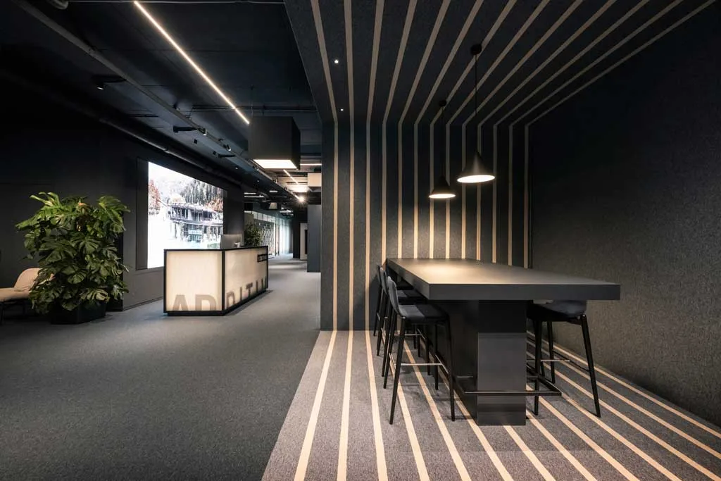 Ingresso con rivestimento a righe nella sede ADDITIVE a Bolzano, progetto di interior design flessibile firmato NOA