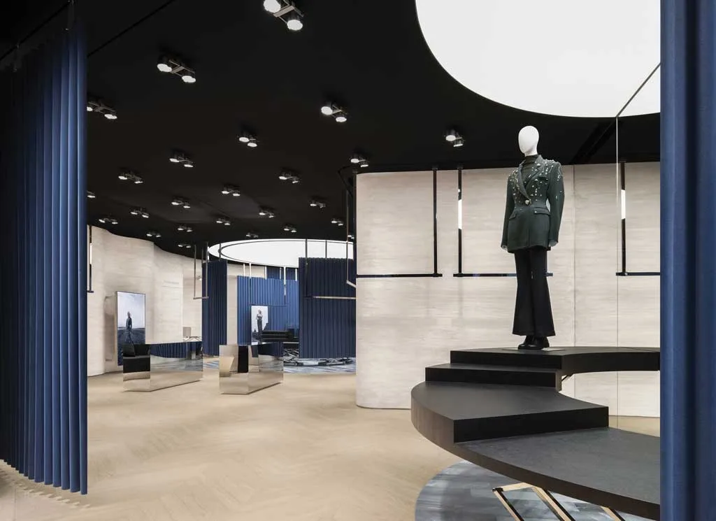 Interni della boutique MITHRIDATE a Guangzhou con layout curvo e tende scenografiche blu