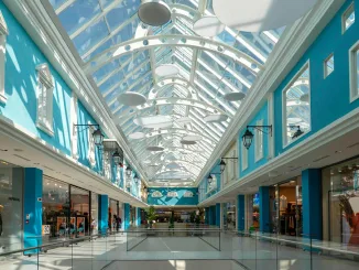 Vista del primo piano ristrutturato del Centro Commerciale Rescaldina con negozi e copertura in vetro