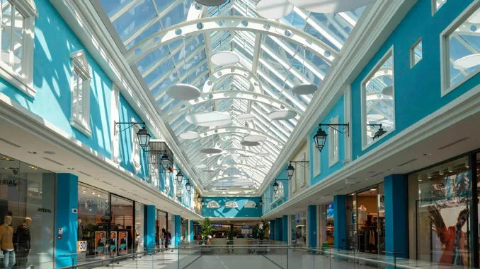Vista del primo piano ristrutturato del Centro Commerciale Rescaldina con negozi e copertura in vetro