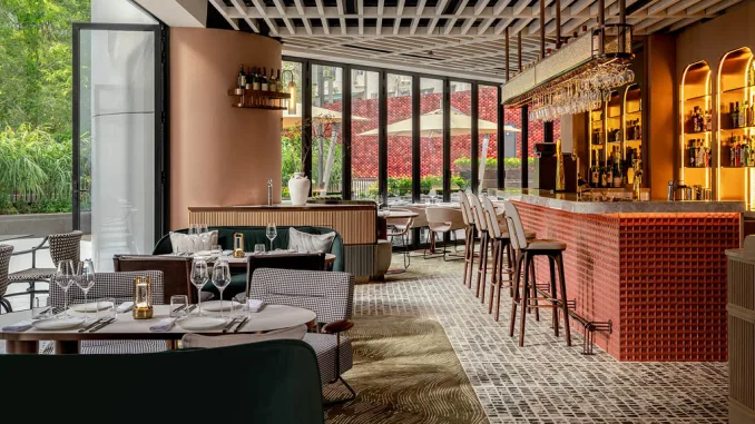 Interni del ristorante Yung’s Bistro a Hong Kong, con bancone bar in rilievo rosso e arredi di design firmati Lim + Lu