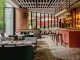 Interni del ristorante Yung’s Bistro a Hong Kong, con bancone bar in rilievo rosso e arredi di design firmati Lim + Lu