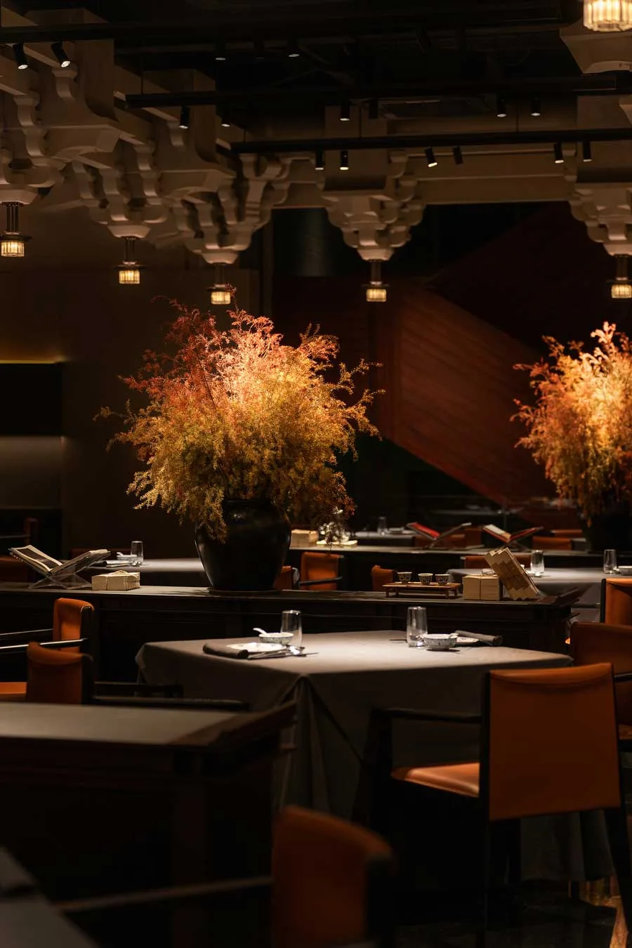 Centro tavola floreale nella sala principale del ristorante GUI TEMPLE a Pechino con luce soffusa e soffitto decorato