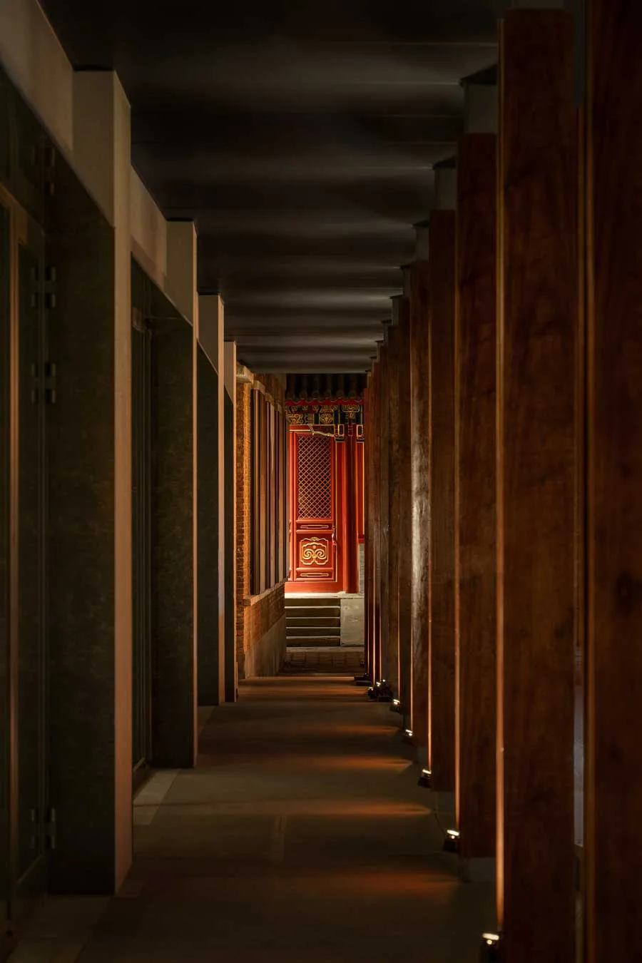Corridoio del ristorante GUI TEMPLE a Pechino con colonne in legno e porta rossa decorata in stile tradizionale