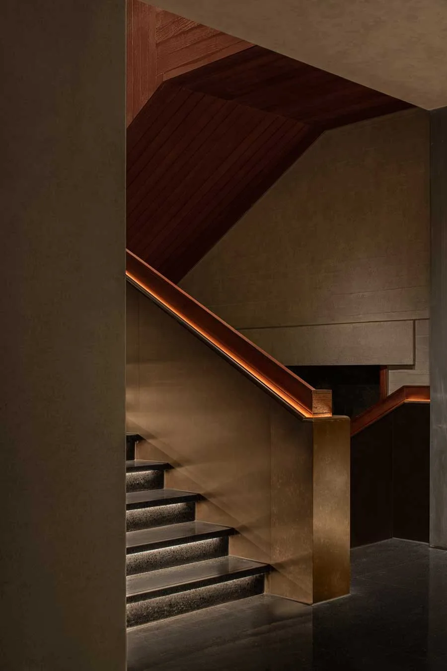 Scala interna del ristorante GUI TEMPLE a Pechino con rivestimenti in ottone e luce perimetrale