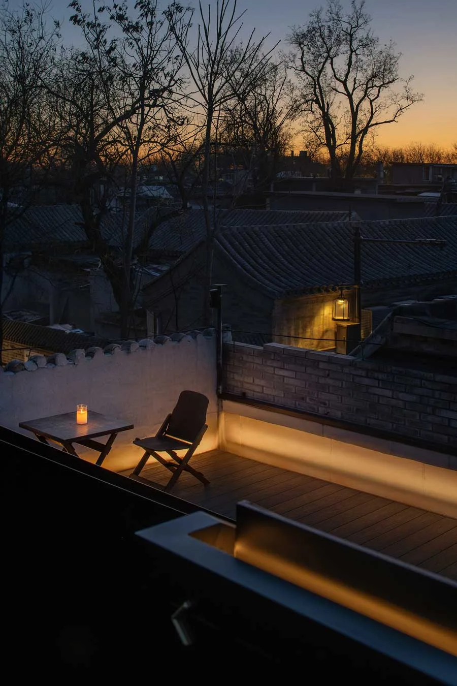 Terrazza del ristorante GUI TEMPLE a Pechino al tramonto con vista sui tetti storici e luce soffusa