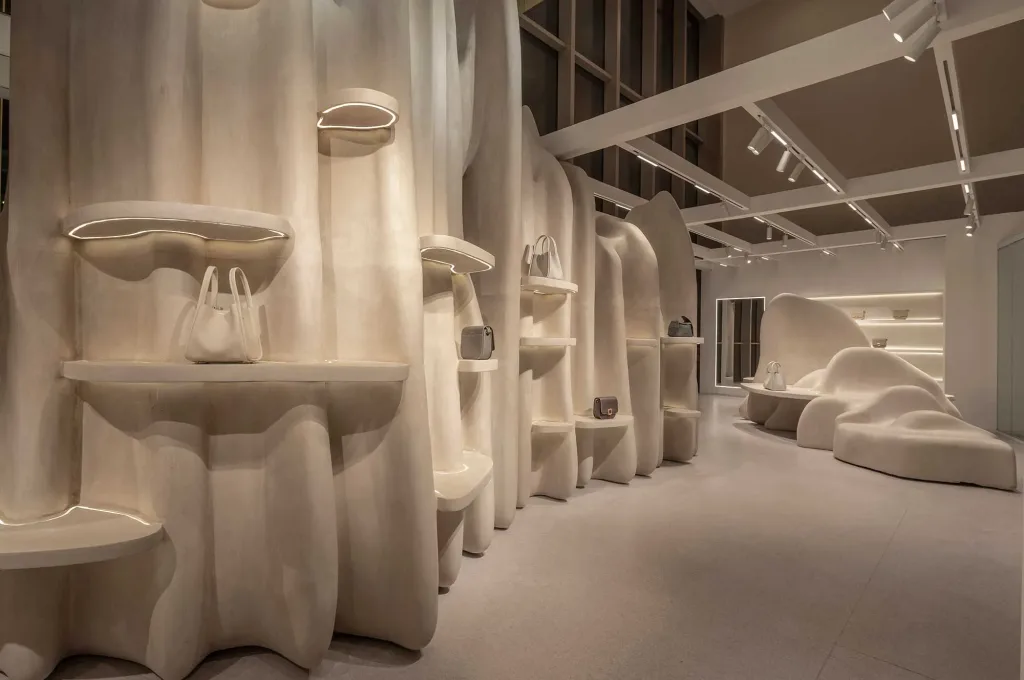 Interni dello store Songmont al Plaza 66 di Shanghai, progettato da ARCHSTUDIO, con arredi scultorei per la progettazione negozi per brand di accessori moda.
