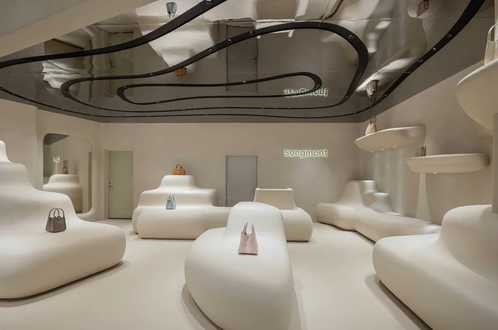 Store Songmont a Shenzhen progettato da ARCHSTUDIO, con espositori organici e soffitto riflettente, esempio di progettazione negozi per brand di accessori moda.