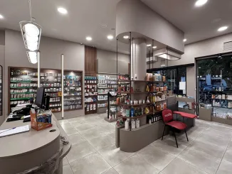 Vista d’insieme della Farmacia Katsios P. con arredi curvi e banco centrale effetto marmo