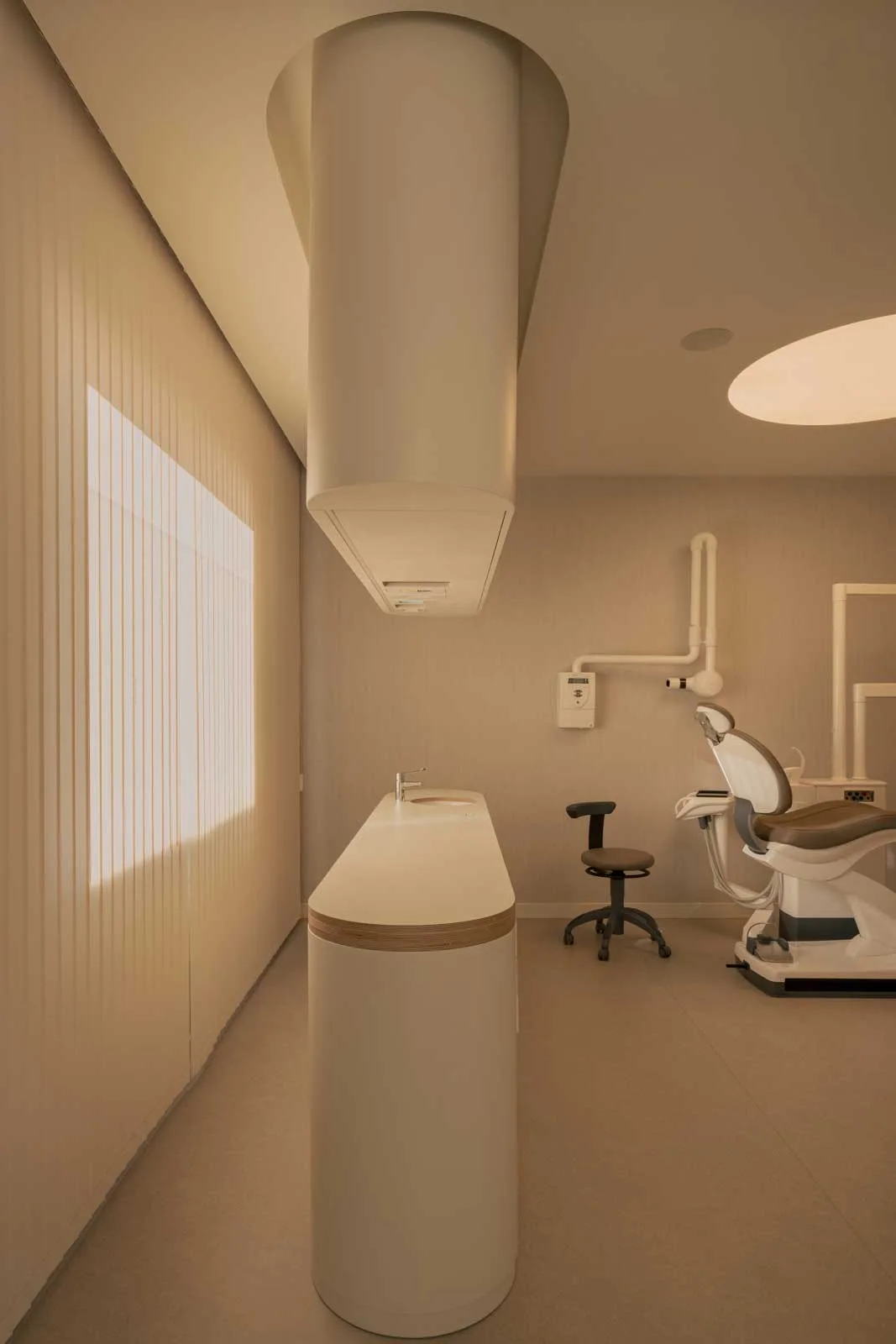 Sala operativa con arredi su misura e luci soft in uno studio dentistico contemporaneo