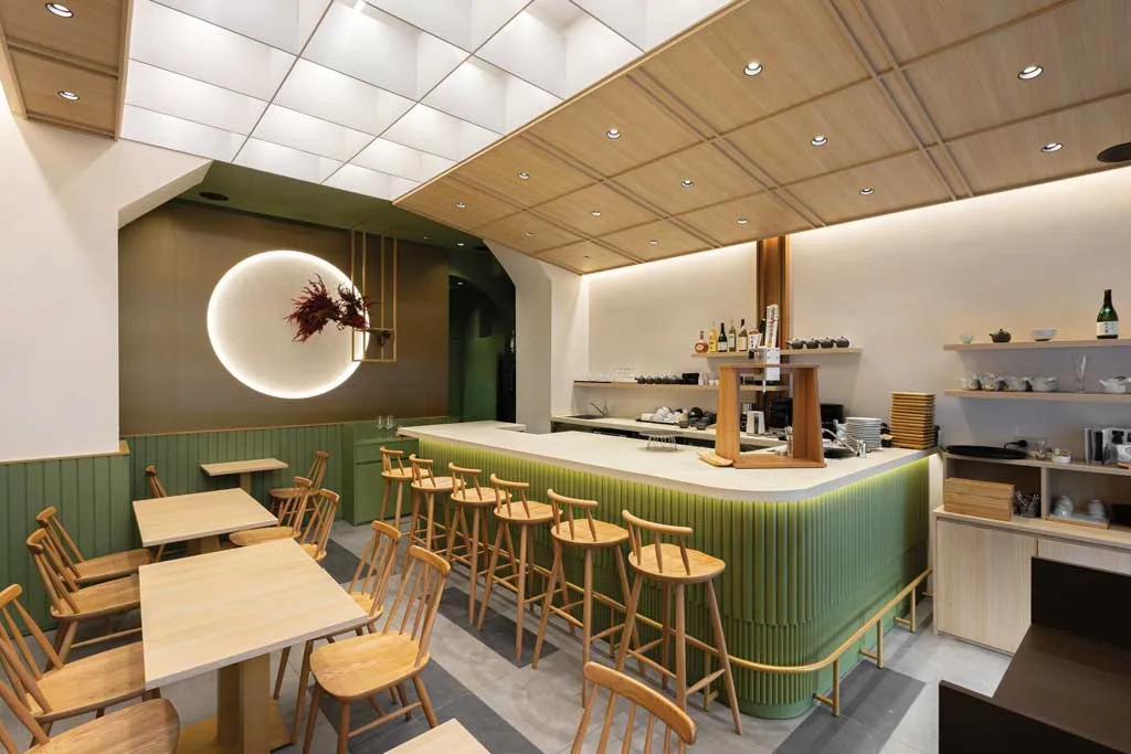 Vista dell’interno del Kagurazaka Saryo Milano con bancone verde matcha, arredi in legno chiaro e luce soffusa ispirata al design giapponese
