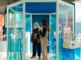 Allestimento colorato e creativo a Milano Home con visitatrici all'interno di uno spazio espositivo dedicato al design e alla decorazione per la casa