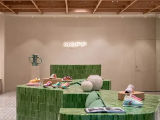 Logo HOFF retroilluminato sopra il banco cassa in ceramica