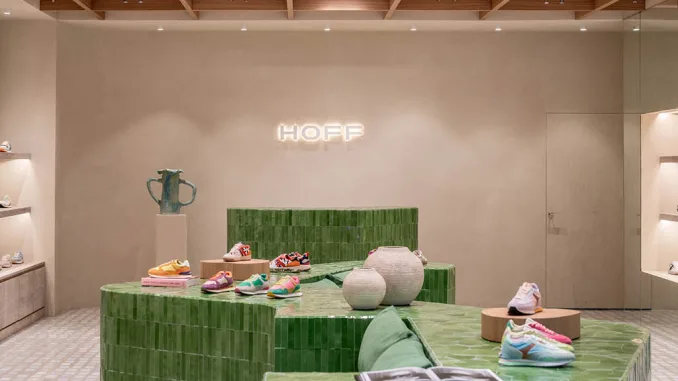 Logo HOFF retroilluminato sopra il banco cassa in ceramica