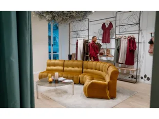 Interno della boutique Dixie a Torino con divano senape e decorazioni floreali.