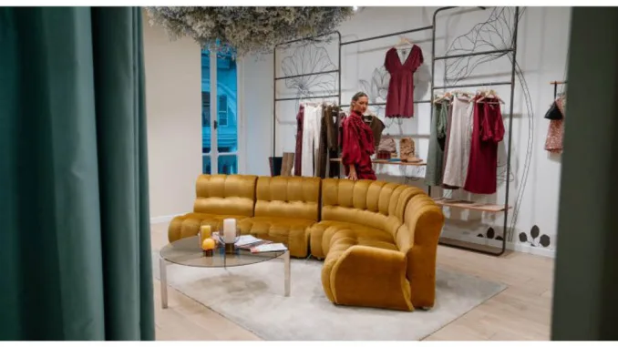 Interno della boutique Dixie a Torino con divano senape e decorazioni floreali.