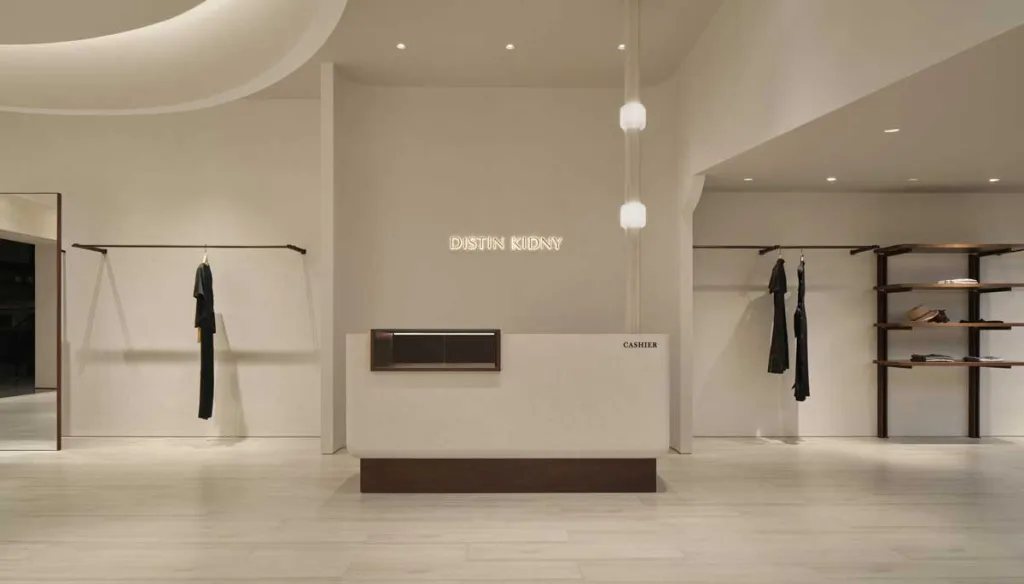 Banco cassa del concept store DISTIN KIDNY a Chongqing con pareti neutre, illuminazione puntuale e arredi in legno scuro