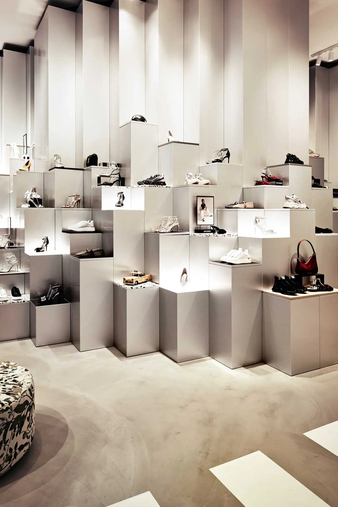 Dettaglio dell’allestimento del concept store Steve Madden nei Paesi Bassi con moduli espositivi retroilluminati a diverse altezze per scarpe e accessori.
