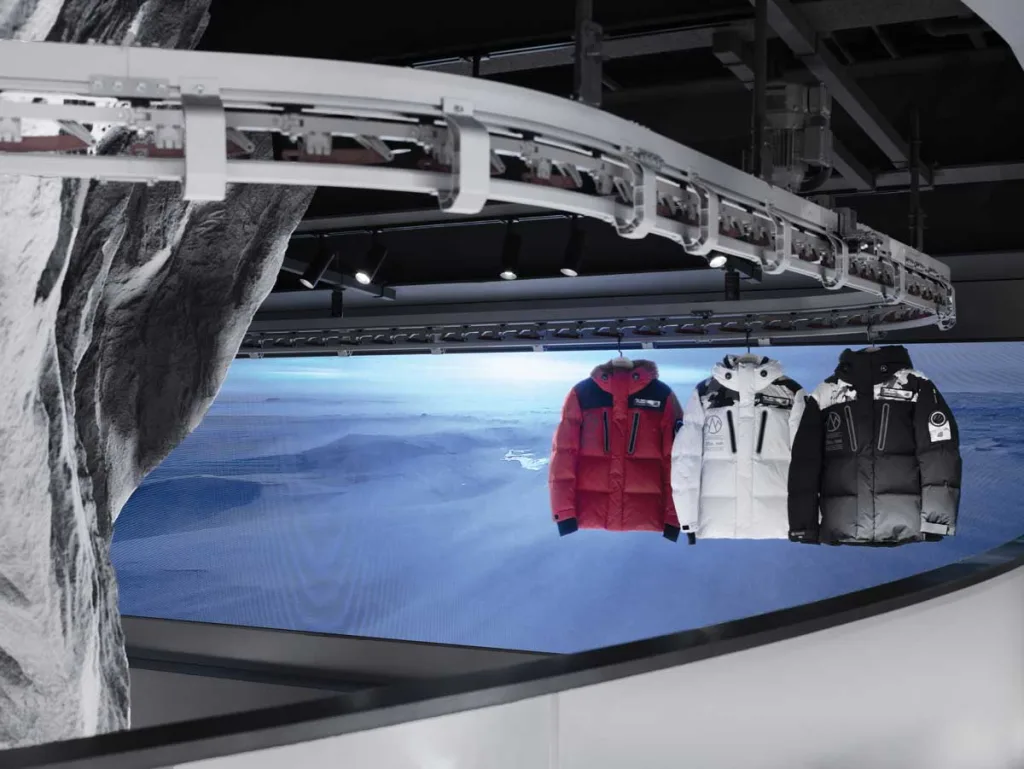 Suspended display of winter jackets with panoramic digital backdrop – dynamic setup at the Bosideng flagship store in Beijing.