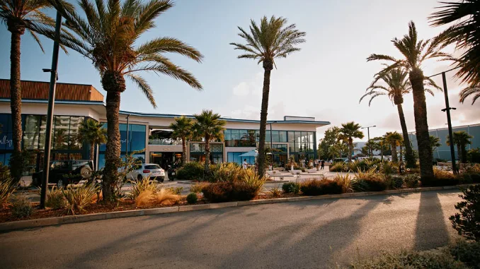 Facciata principale di IBIZA Gallery a Playa d’en Bossa – nuovo polo lifestyle tra design contemporaneo, palme mediterranee e architettura vetrata.