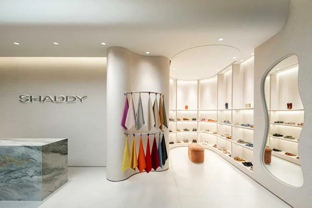 Dettaglio del Shaddy Store a West Jakarta con banco cassa in marmo, campioni tessili colorati e specchio dalle linee fluide