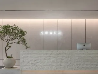Reception in pietra naturale presso lo showroom moda a Foshan progettato da LubanEra Design – minimalismo materico e luce integrata