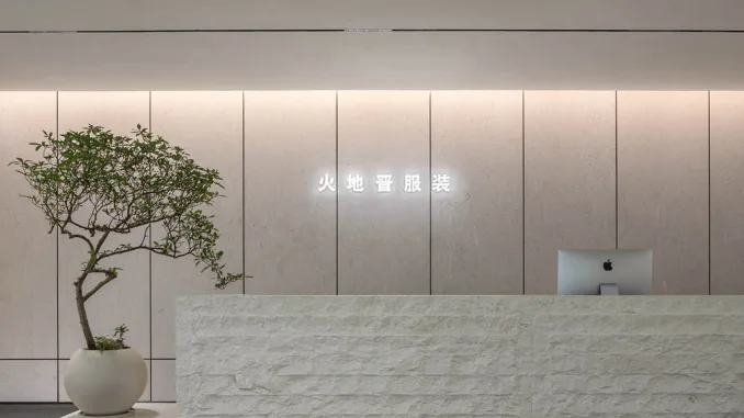 Reception in pietra naturale presso lo showroom moda a Foshan progettato da LubanEra Design – minimalismo materico e luce integrata